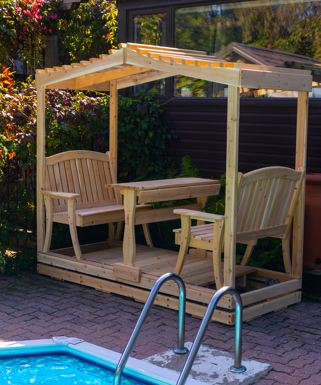 Premium 4-person poolside face-to-face cedar glider swing with a decorative open slatted wooden pergola roof and built-in center table.