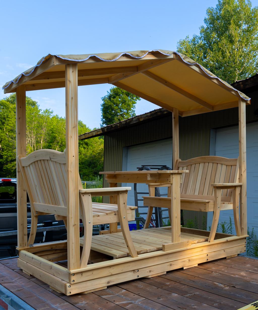 Handcrafted outdoor wooden 4-person glider swing featuring a tan fabric canopy roof and integrated center dining table.