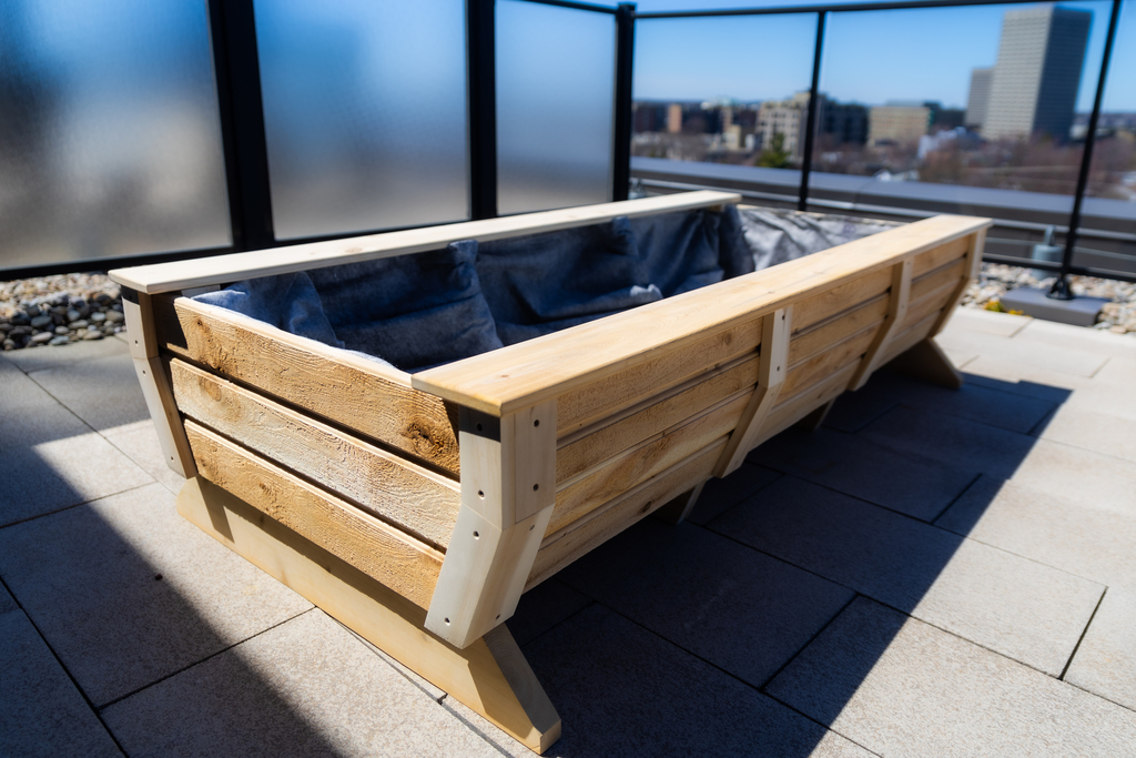 Matteout dual-purpose cedar planter box bench combo styled for a backyard deck or a high-rise rooftop patio.
